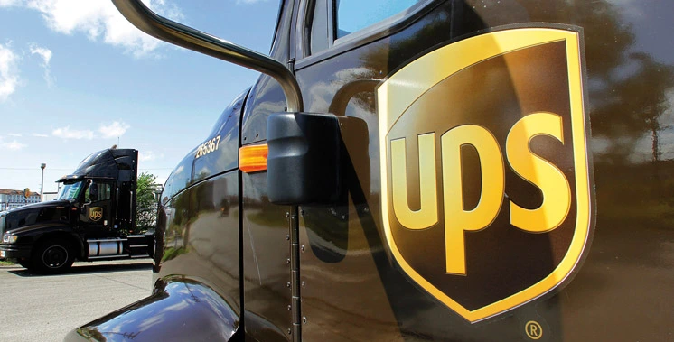 UPS employees standing in front of a delivery truck, symbolizing new job opportunities.