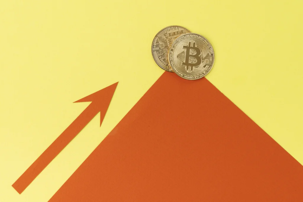Bitcoin symbol in front of an upward-trending chart showing price surge