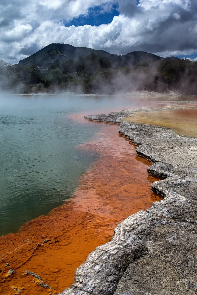 Hydrothermal eruption at Black Diamond Pool in Yellowstone National Park, releasing steam and debris into the air.