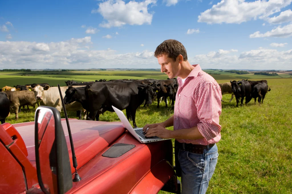 Independent digital media creators working in a rural American setting, using laptops and mobile devices to share local news online.