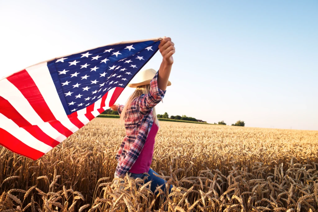 A drought-affected American farmland with dry soil, damaged crops, and rising heat haze representing climate change effects on agriculture.