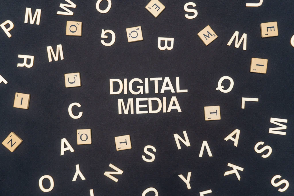 Independent digital media creators working in a rural American setting, using laptops and mobile devices to share local news online.