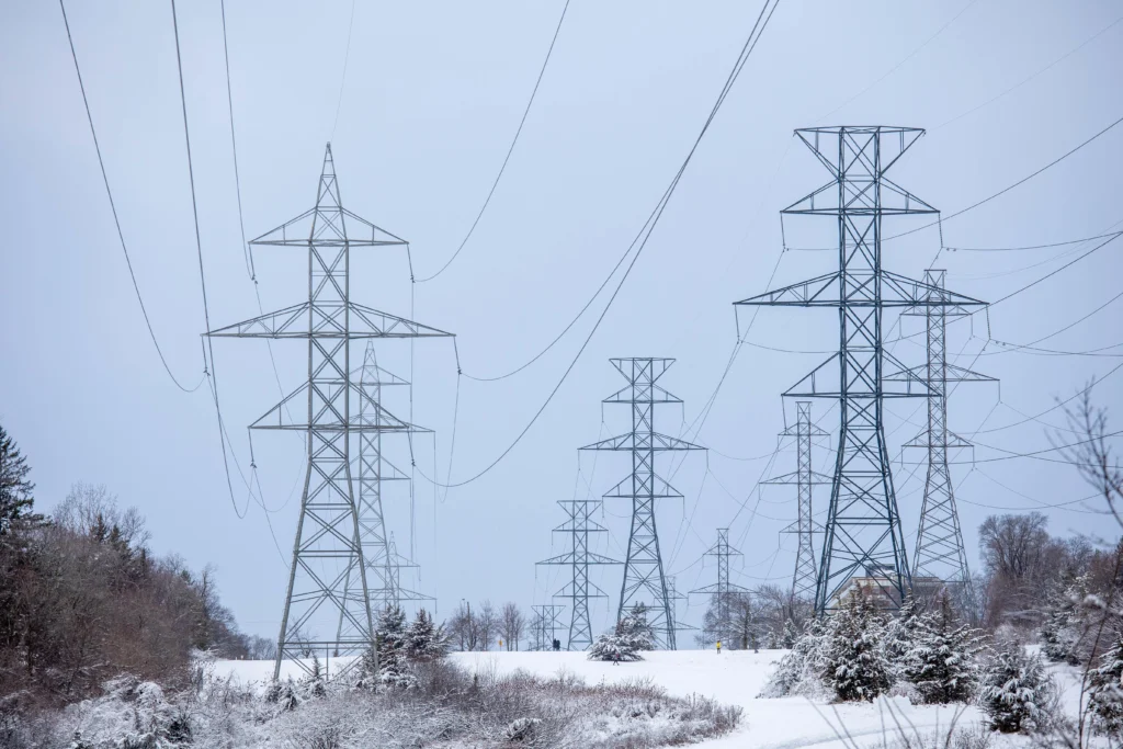 Temporary energy crisis during extreme U.S. cold wave, showing power lines under heavy frost.