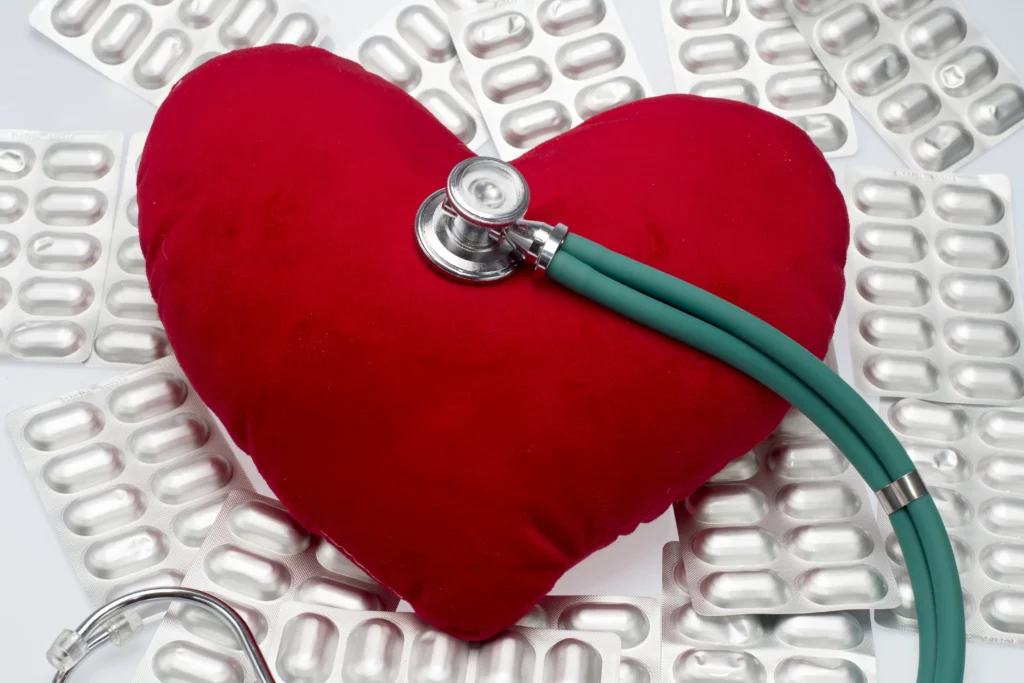 Melatonin supplement bottle beside a red heart symbol, representing the benefits of melatonin for cardiovascular health
