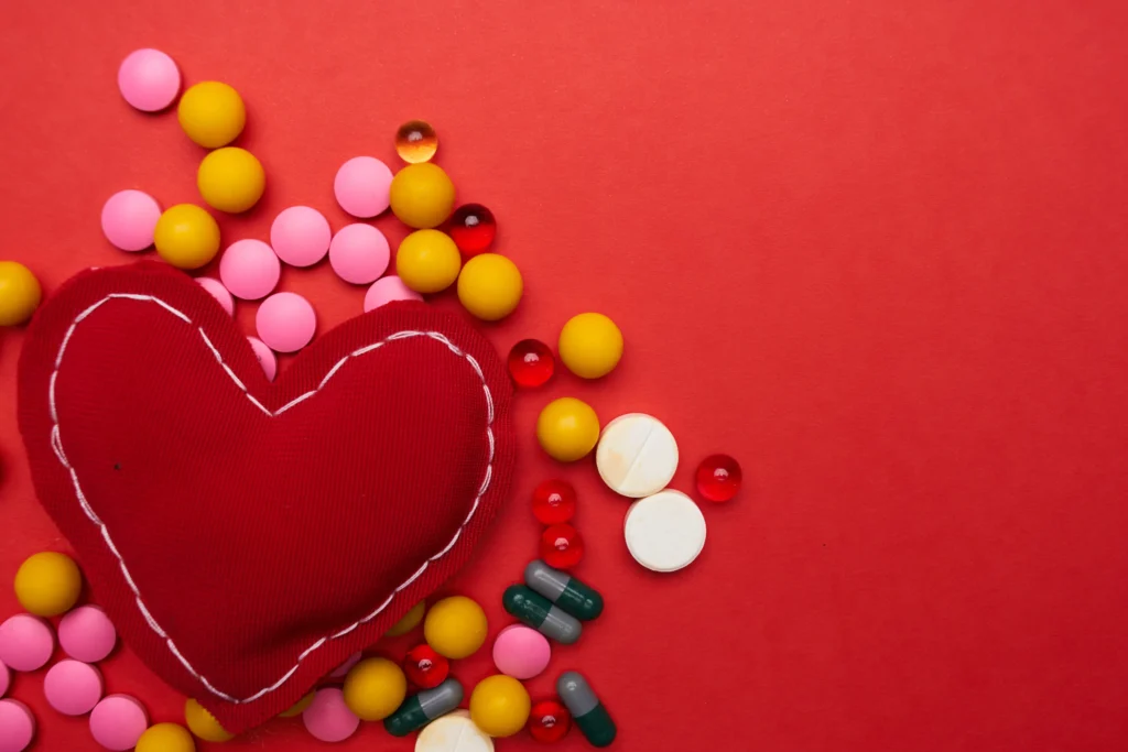 Melatonin supplement bottle beside a red heart symbol, representing the benefits of melatonin for cardiovascular health