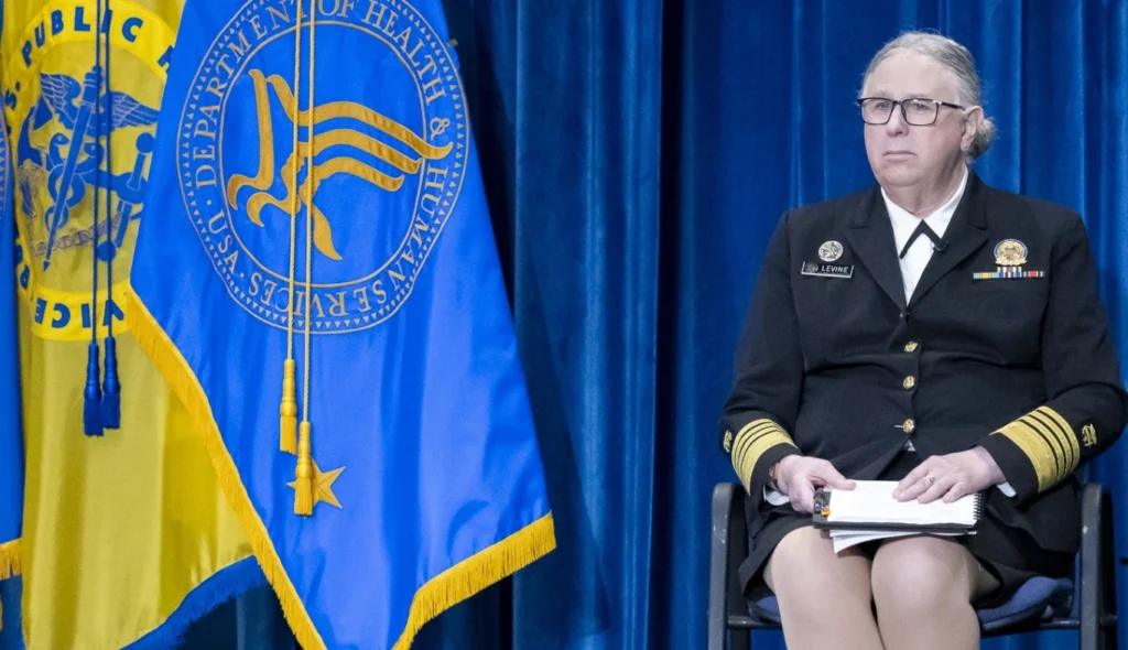 Admiral Rachel Levine speaking at a public event, highlighting challenges of institutional deadnaming