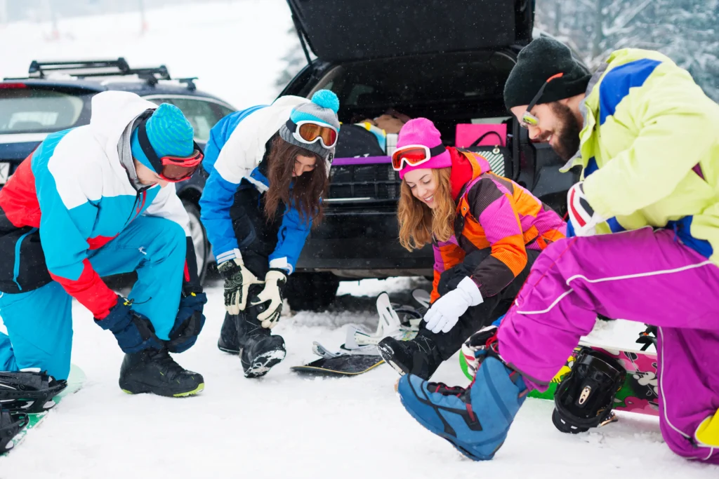 Skiers wearing helmets and proper gear on a snowy slope, practicing ski safety