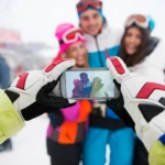 Skiers wearing helmets and proper gear on a snowy slope, practicing ski safety