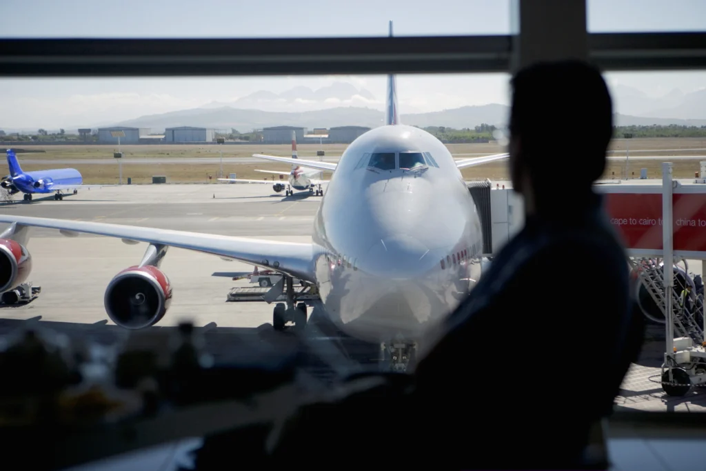 Delta Airlines counter with VIP signage and passengers in line, highlighting suspension of congressional perks