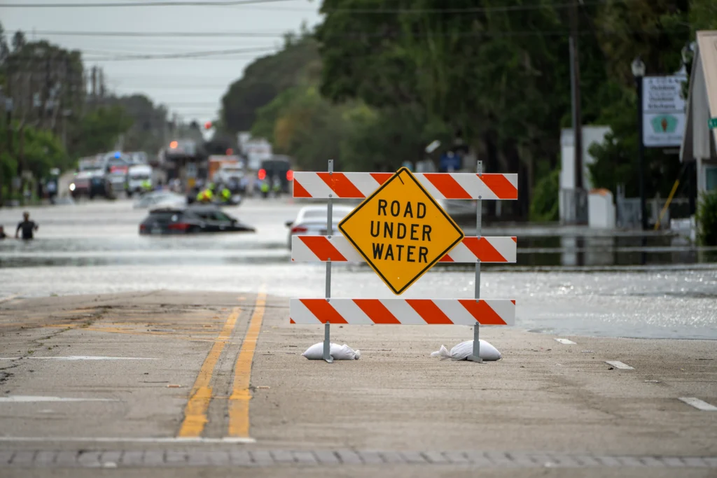 Flooded street in Oahu, Hawaii, with emergency rescue operations underway during severe flash flooding.