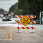Flooded street in Oahu, Hawaii, with emergency rescue operations underway during severe flash flooding.