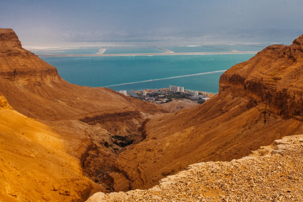 Donald Trump speaking with a map of the Strait of Hormuz in the background