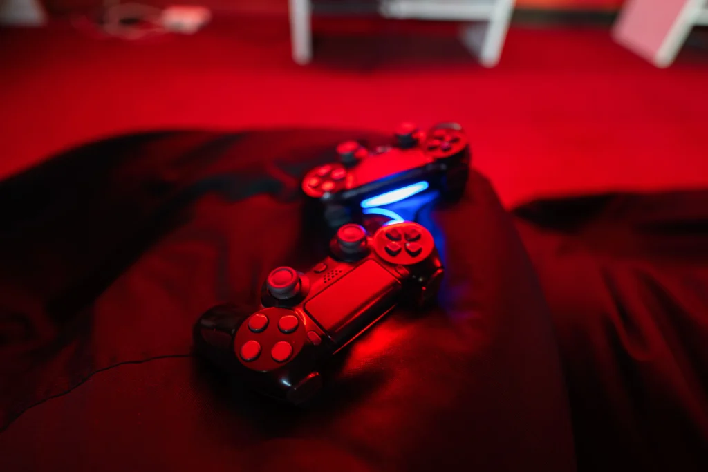 Gamer holding a PlayStation controller while checking PlayStation Network status on screen during connection issue