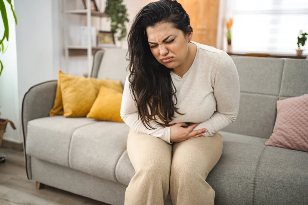 A healthcare professional reviews data on a digital screen showing a rise in norovirus cases across the United States, while a patient experiences symptoms of a stomach virus.