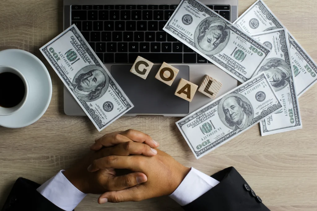 A person managing personal finances with a laptop, calculator, and budget planning notes on a desk representing financial discipline and money management