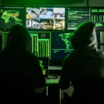 Digital illustration of a U.S. gas station under a cyberattack with hackers targeting fuel monitoring systems and cybersecurity warning graphics.