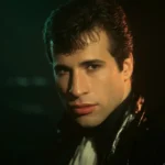 John Travolta in a contemplative pose with dim Hollywood-style lighting symbolizing his long absence from the film industry.