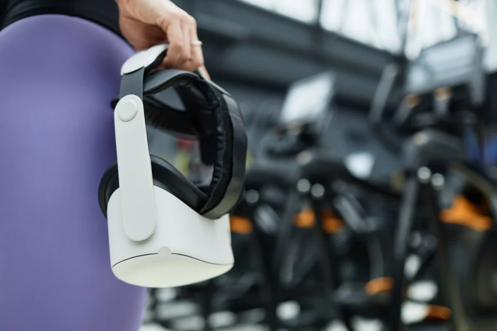 Intersection of Virtual Reality and Fitness Person wearing a virtual reality headset while performing an interactive fitness workout in a modern gym, with digital workout metrics and immersive virtual environments displayed around them.